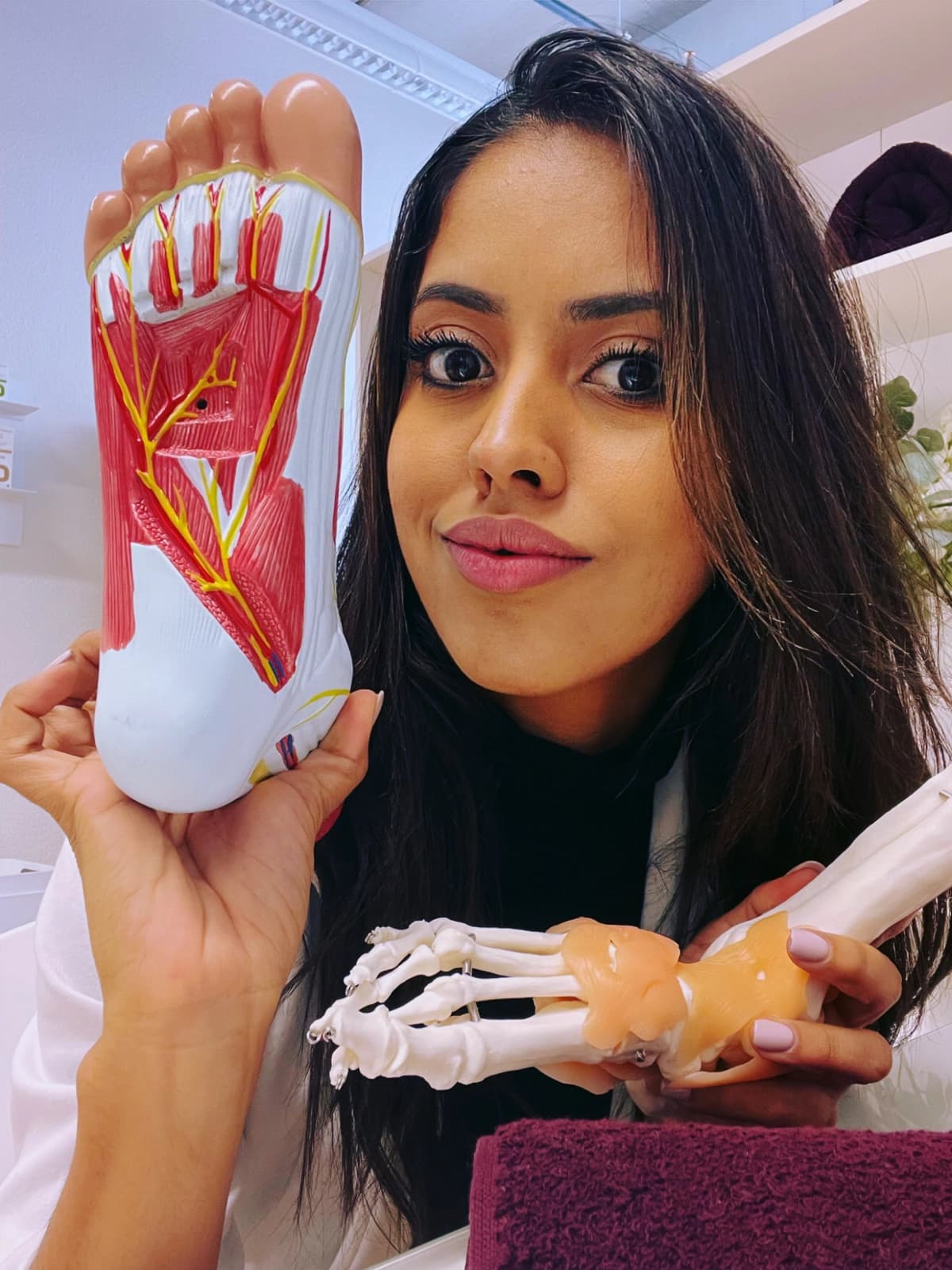 Yasmin De Souza Santos mit anatomischen Fussmodellen